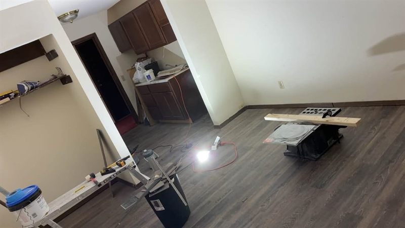 The finished dark vinyl plank floor running through to the kitchen doorway.