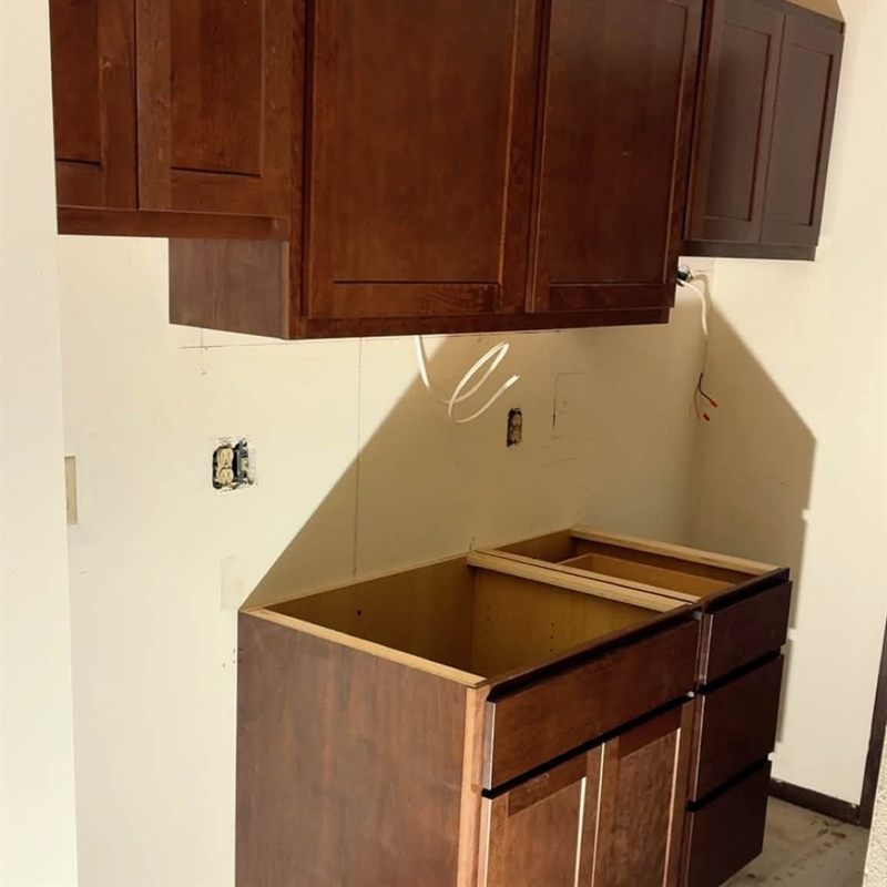 Kitchen with newly installed dark wood upper and base cabinets.
