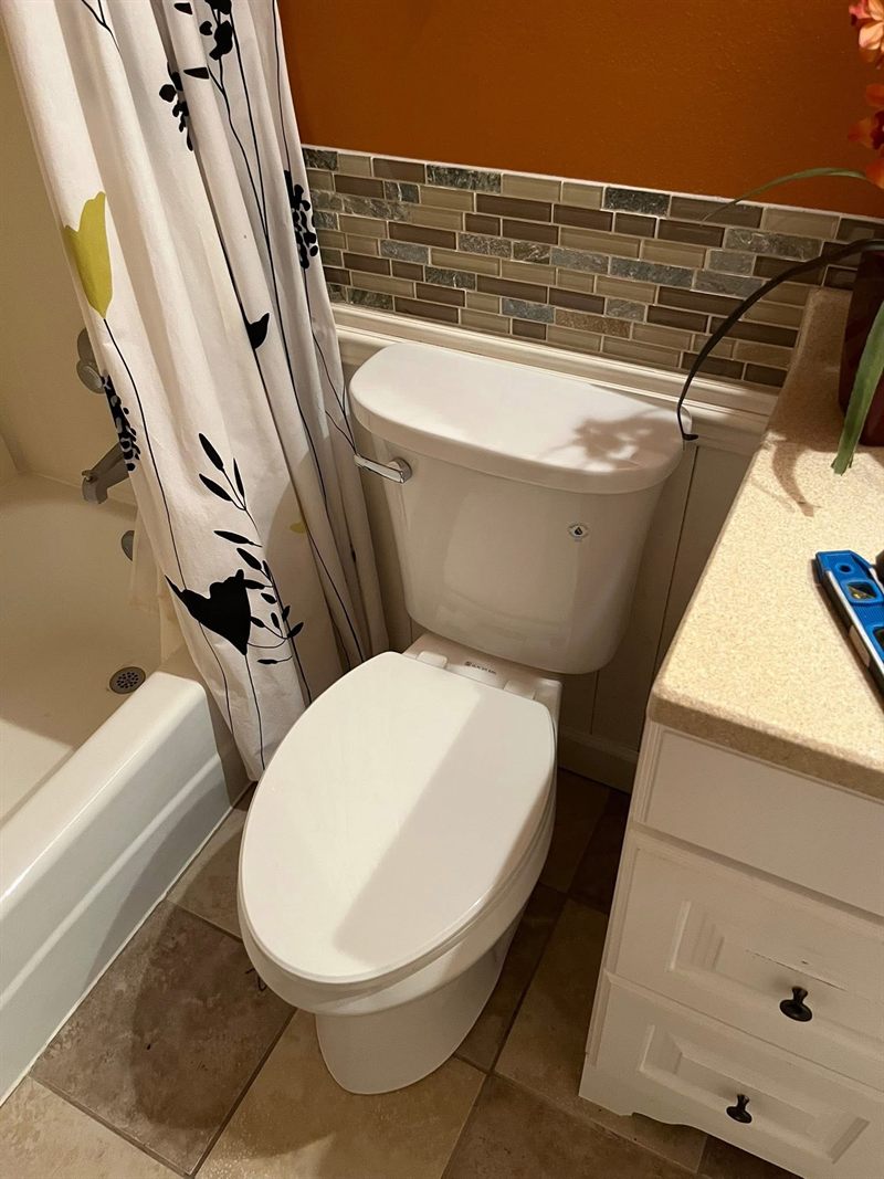 A bathroom with a new toilet installed, sealed, with the floor cleaned up.
